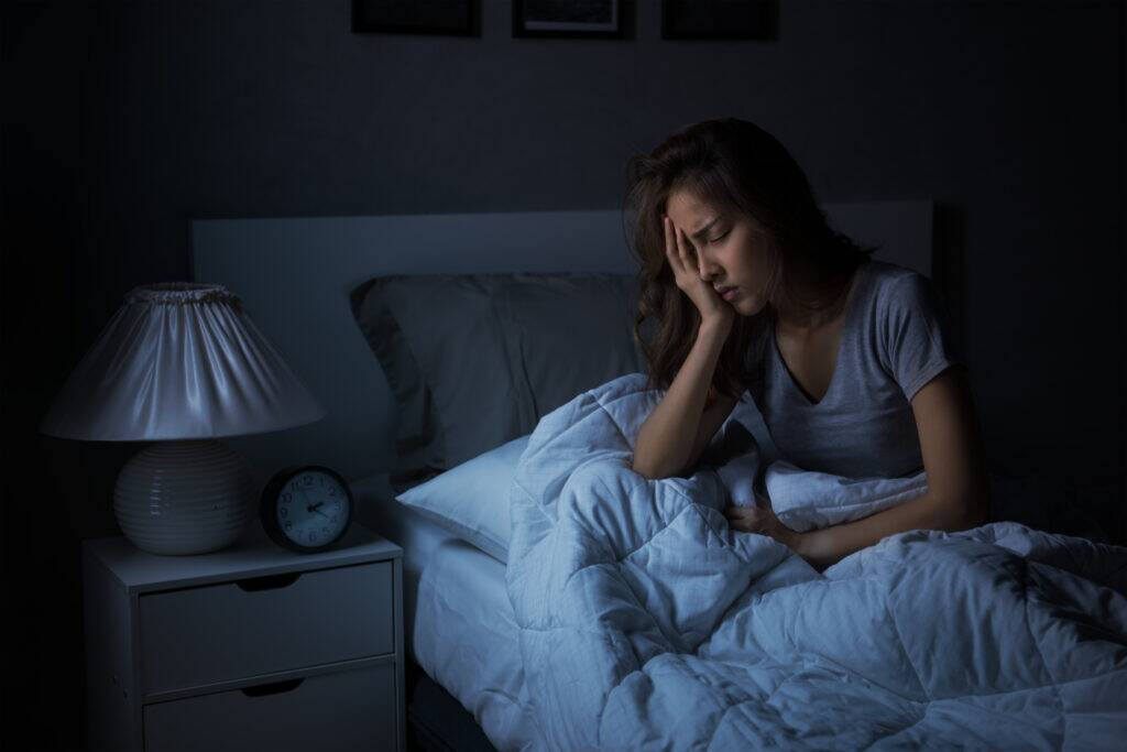 woman struggling to sleep from alcohol and muscle pain