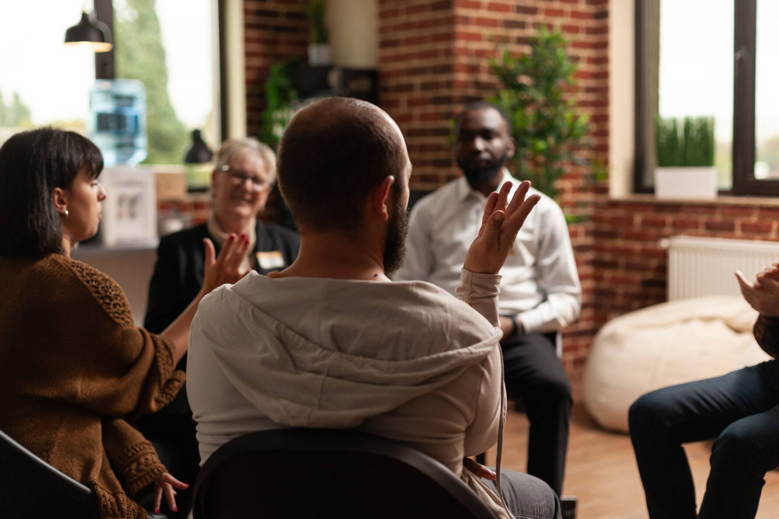 group of sober people in recovery support group tackling triggers and cravings in substance abuse recovery