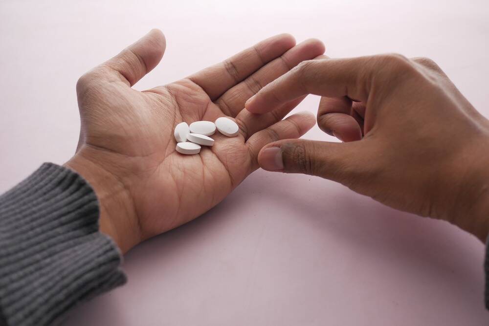 man holding adderall pills, adderall addiction and abuse