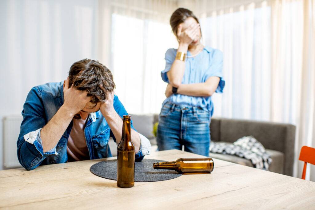 Drunk man suffering from alcoholism feeling depressed and arguing with wife