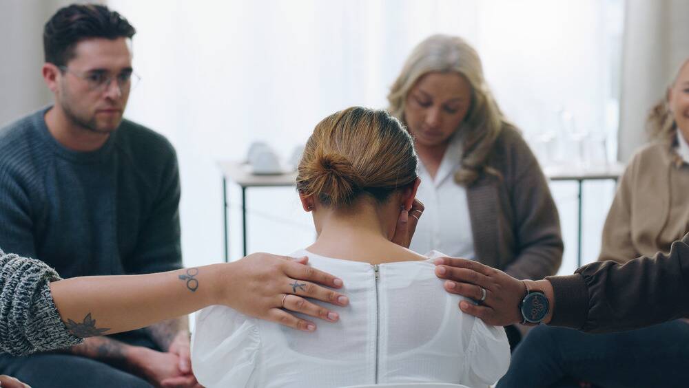 woman in recovery support group meeting for drug and alcohol addiction in professional drug rehab program